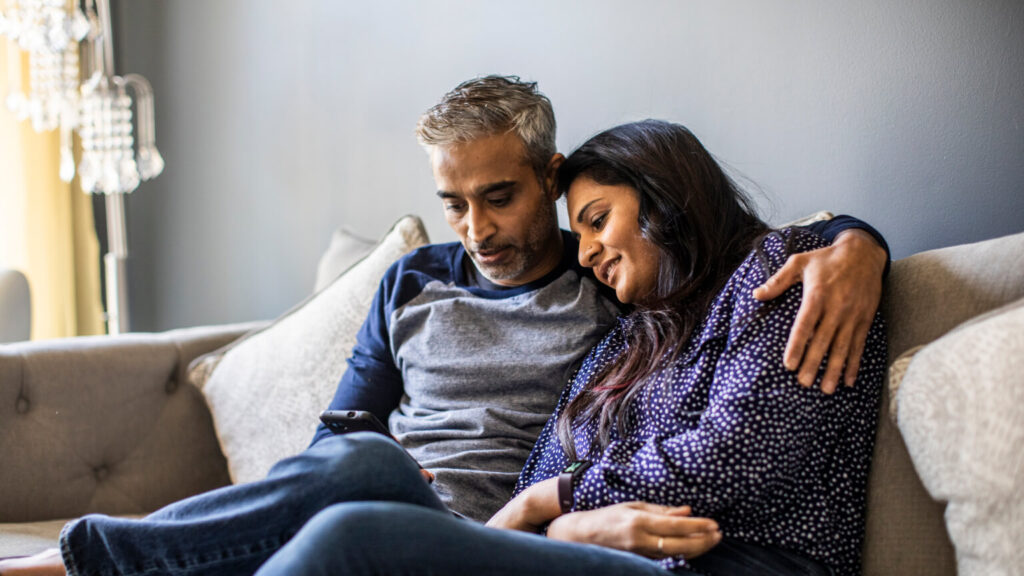 Husband and wife embracing on couch