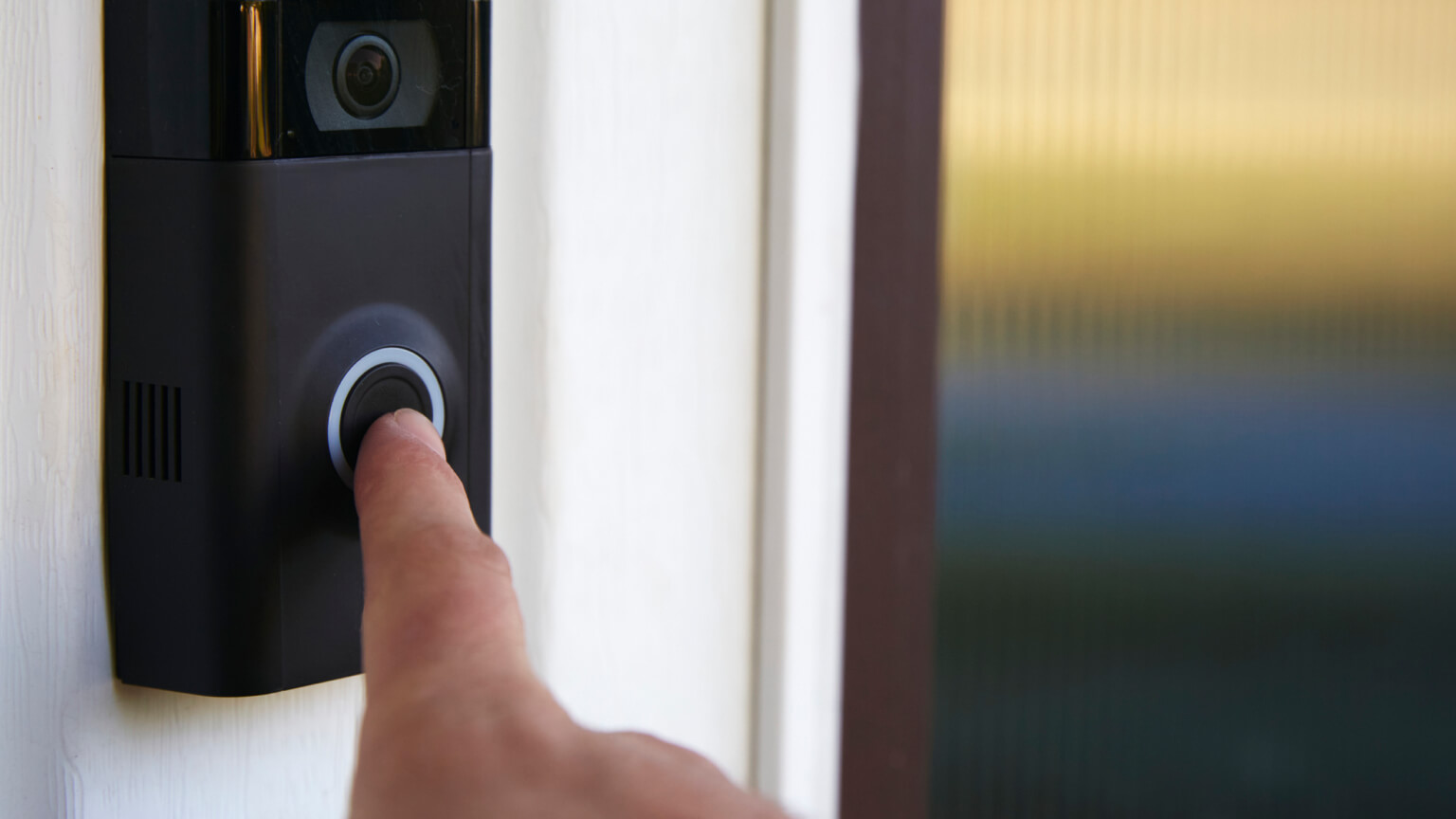 Close up shot of a person ringing a smart doorbell