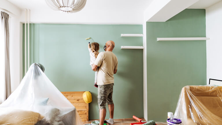 Teamwork in house renovation - daddy and daughter painting together
