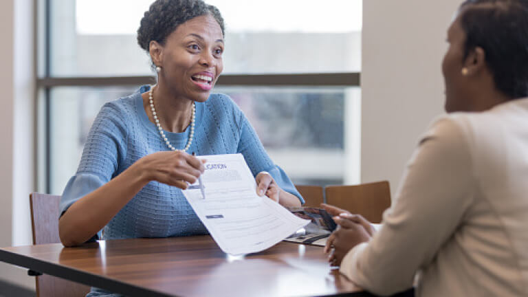 Senior female personal banker shows client account application