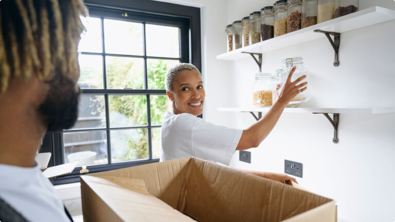 Couple enjoying unpacking and organizing their new kitchen