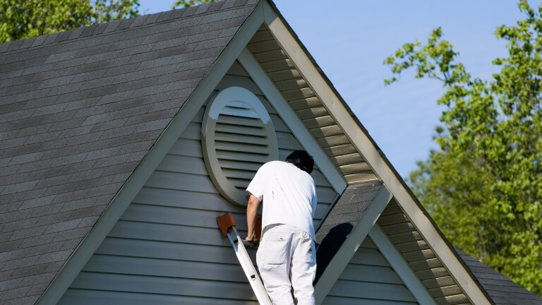 Painter working at roofline