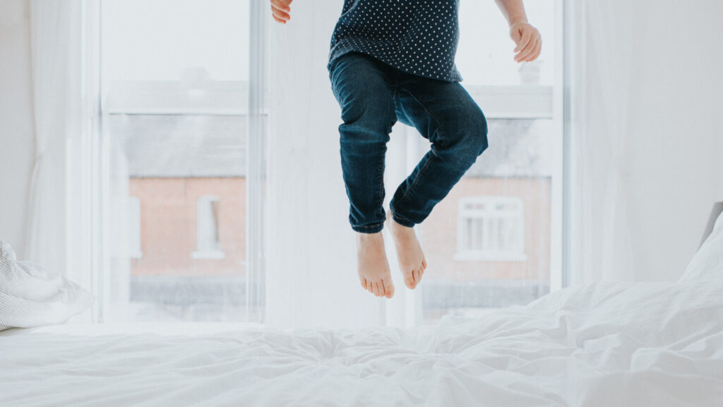 Child bouncing on a bed