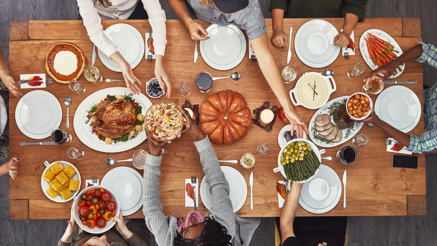 Shot of a group of people sitting together at a dining table ready to eat