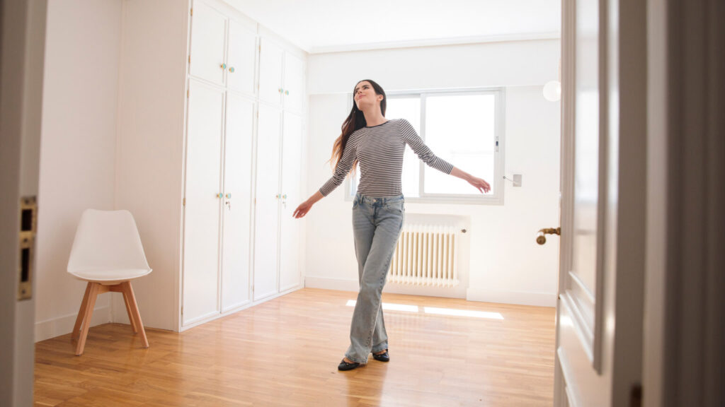 Young woman in an empty apartment looking around
