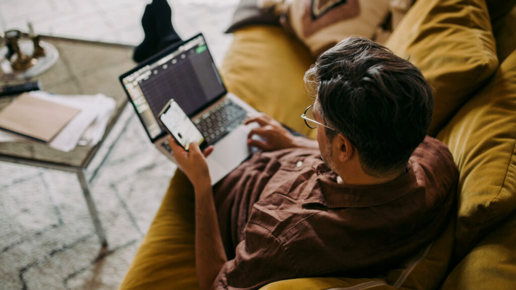 High angle view of male entrepreneur working on laptop in living room