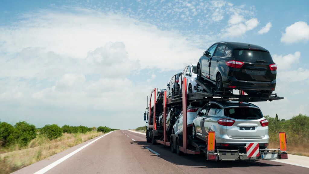 Articulated truck transport of automobiles driving on the road