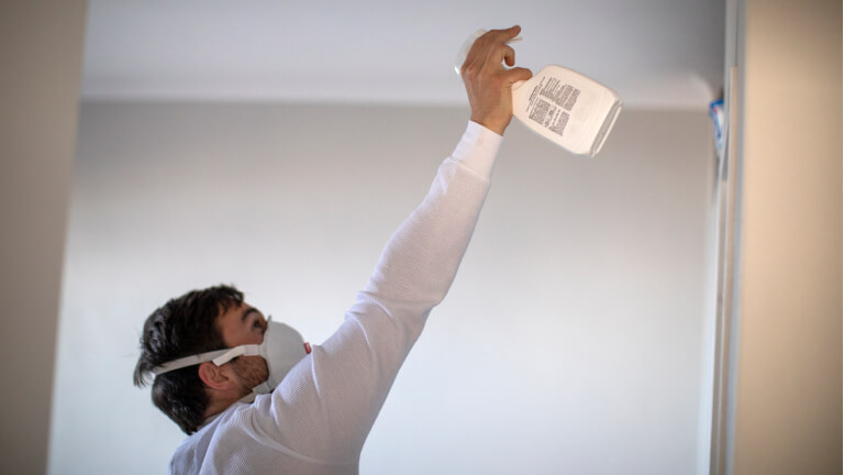 Adult man getting rid of mold in his house.