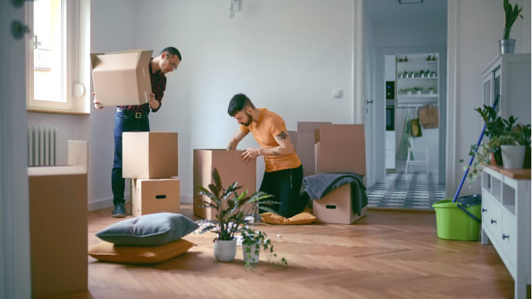 Homosexual couple unpacking boxes in a new home
