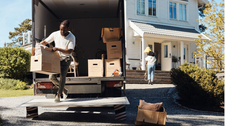 Full length of man unloading cardboard box from van